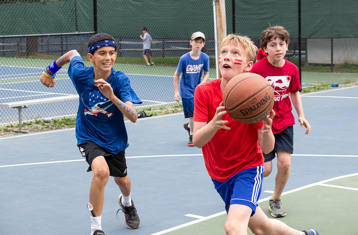 Three campers playing basketball